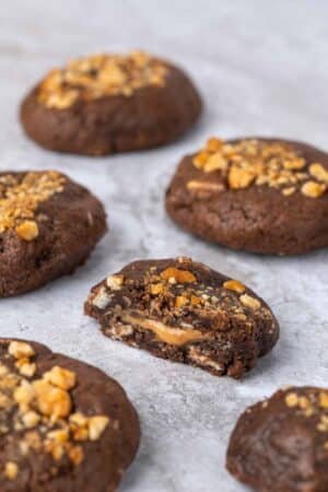 Avec sa base chocolatée, ses pépites de chocolat blanc et son cœur fondant au beurre de cacahuète, ce cookie fourré au beurre de cacahuète est une véritable gourmandise à déguster à tout moment de la journée.